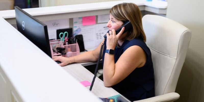Dental receptionist dealing with an enquiry